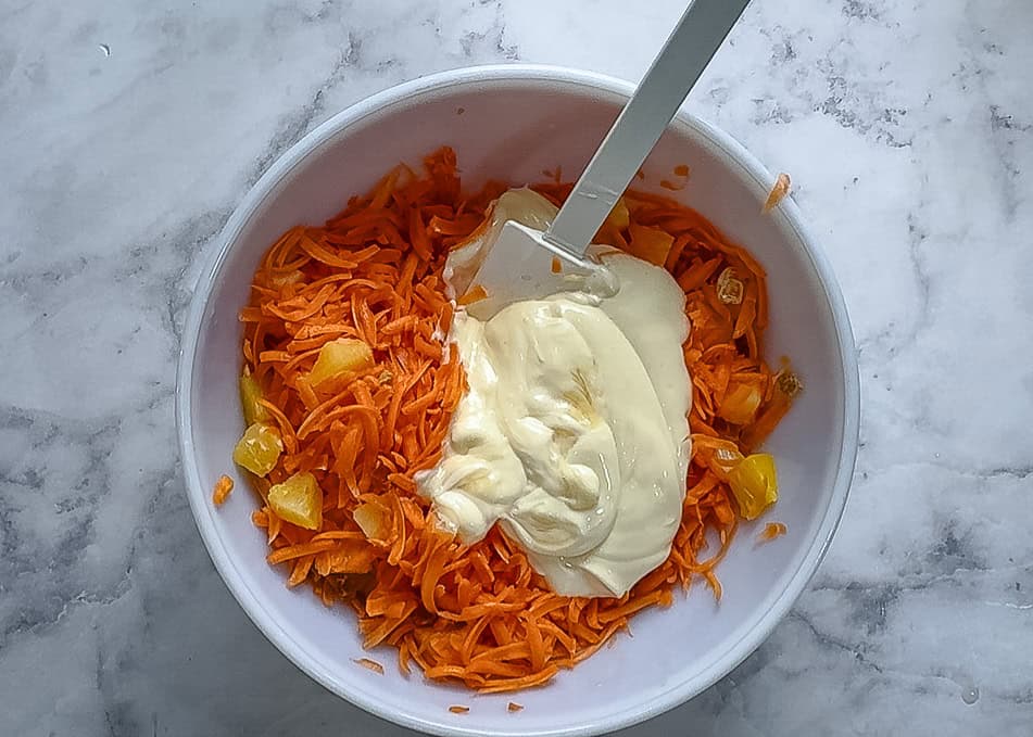 Adding the dressing to the carrot mixture 