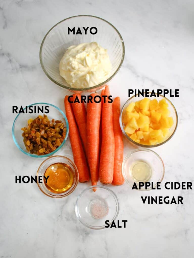 all of the ingredients for carrot salad -Carrots , Mayo, pineapple , raisins , honey , apple cider vinegar , and salt . 