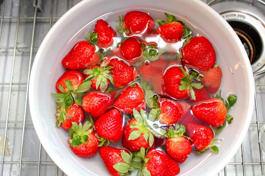 Strawberries soaking in a white bowl