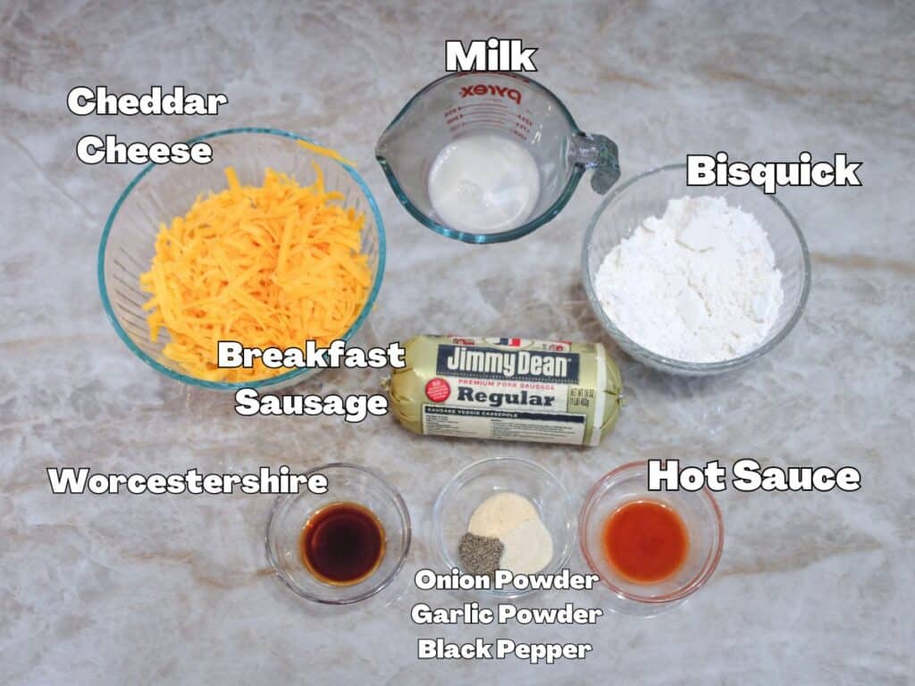 Ingredients for sausage balls including cheddar cheese, Bisquick baking mix, milk, Jimmy Dean breakfast sausage, Worcestershire sauce, hot sauce, onion powder, garlic powder, and black pepper.
