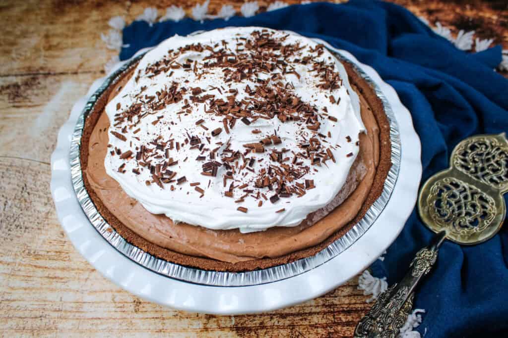 Easy no bake chocolate cream pie topped with whipped topping and chocolate shavings in a chocolate crust