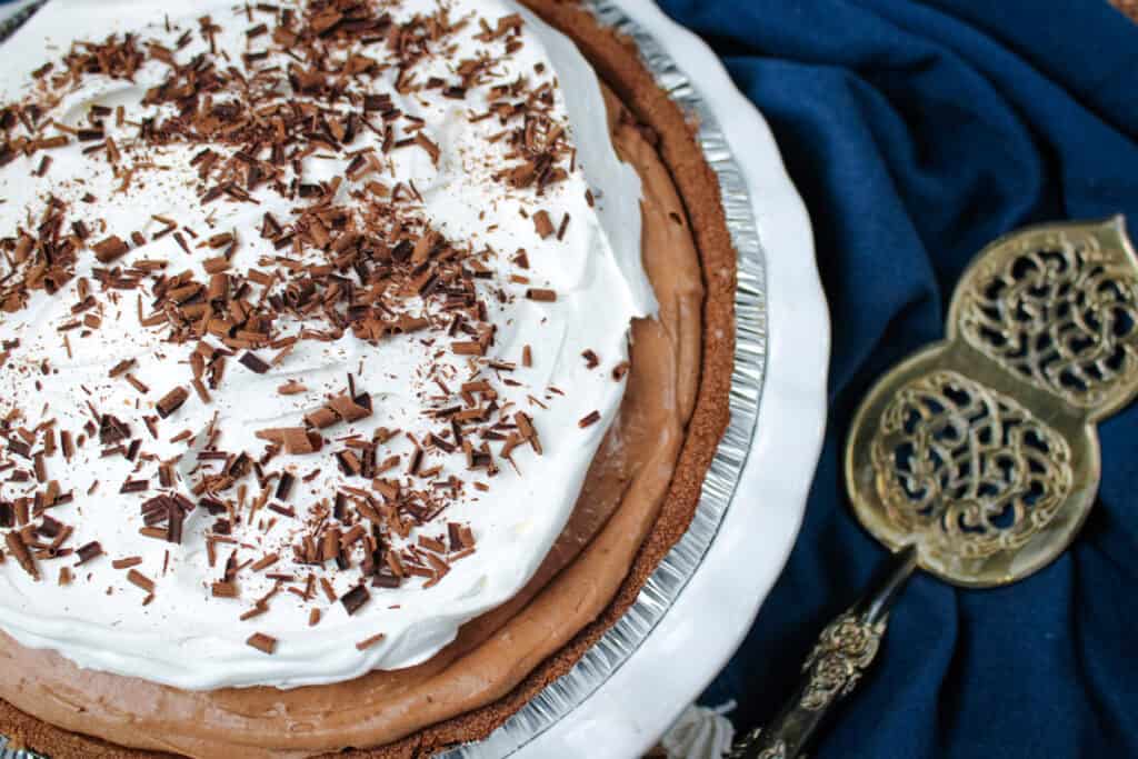 Close up of chocolate cream pie with fluffy whipped topping and chocolate curls