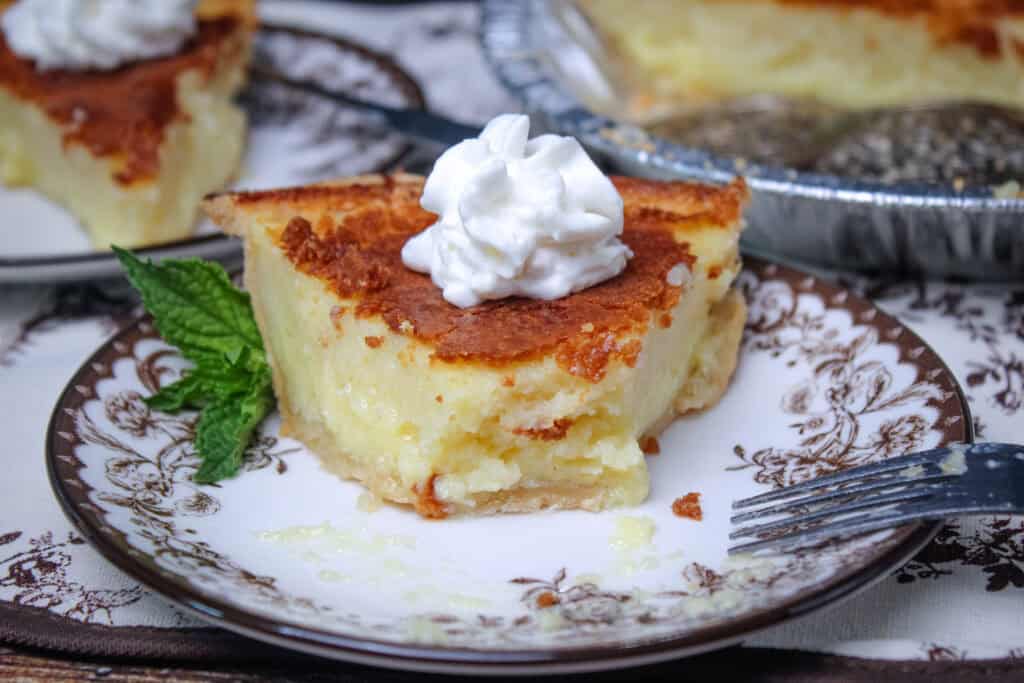Close-up of partially eaten slice:Close-up of creamy Southern Buttermilk Pie with a golden brown top